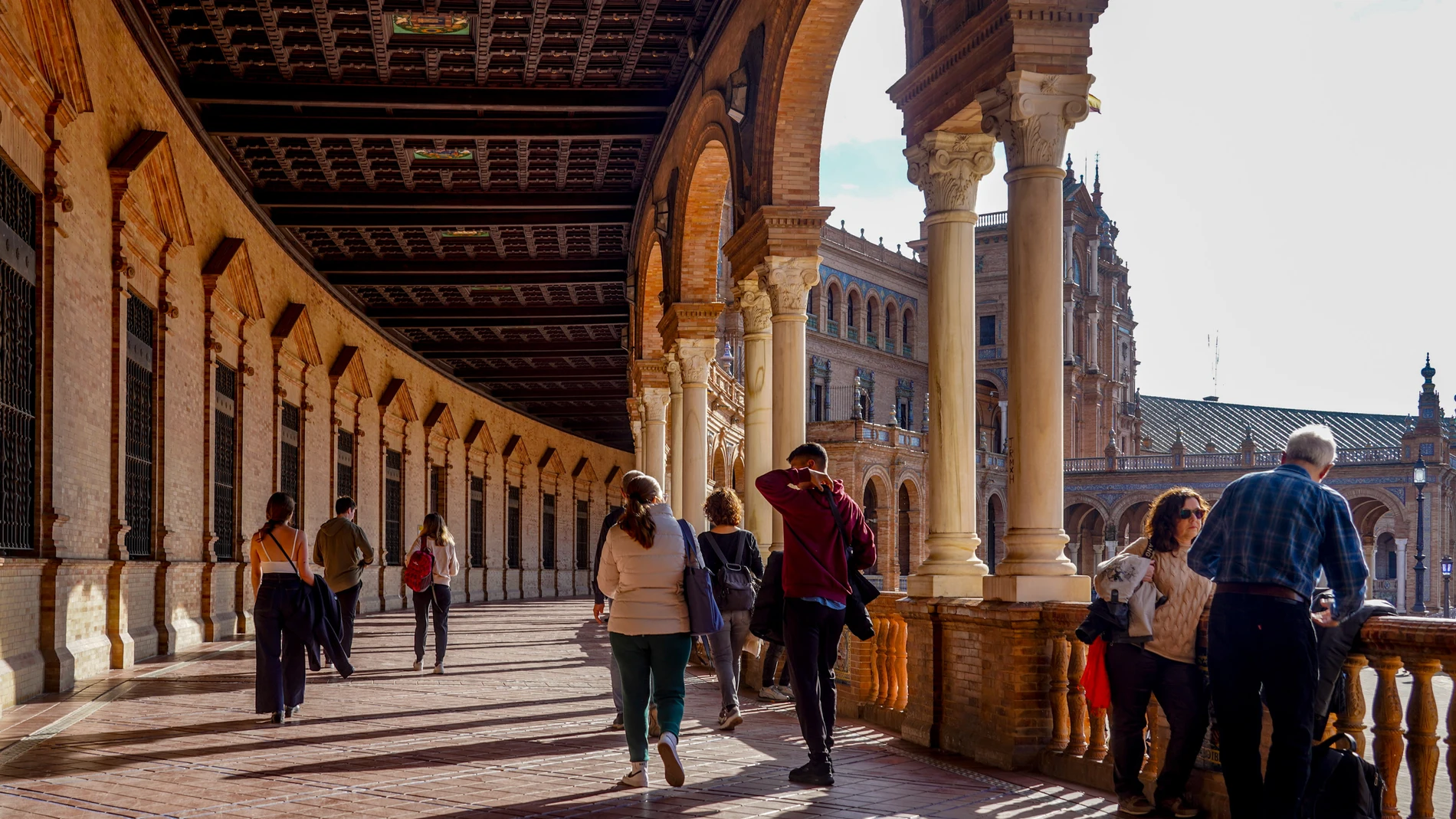 Turistas recorriendo y admirando la Plaza de España de Sevilla
