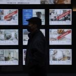 Un hombre pasa por delante de un escaparate de una inmobiliaria
