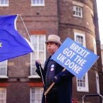 Un manifestante anti-Brexit sostiene un cartel y la bandera de la UE durante una protesta en Londres