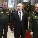 El presidente ruso Vladimir Putin, en el centro, escoltado por el ministro de Defensa ruso Sergei Shoigu, a la derecha, y el Estado Mayor Valery Gerasimov caminan después de asistir a una reunión ampliada de la Junta del Ministerio de Defensa ruso en el Centro de Control de Defensa Nacional en Moscú