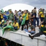 Simpatizantes de Jair Bolsonaro en el tejado del Congreso de Brasil