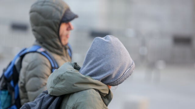 Dos presonas se protegen del frío con abrigos y gorros mientras pasean