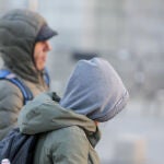 Dos presonas se protegen del frío con abrigos y gorros mientras pasean