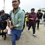 Varios hombres trasladan a un herido en los enfrentamientos con la Policía en Arequipa (Perú)
