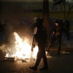 Miembros de la Policía intentan controlar una fogata sobre una vía, durante una nueva marcha antigubernamental en Lima