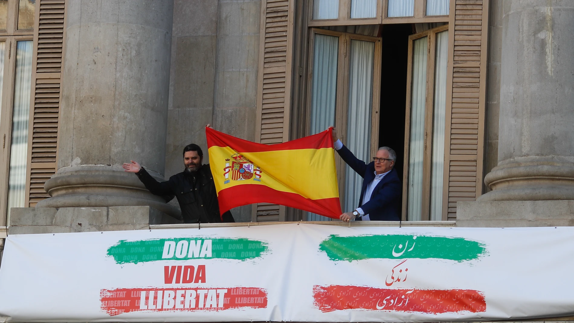 Paco Sierra, de Cs, y Josep Bou, del PP, sacan una bandera España en el balcón del Ayuntamiento de Barcelona durante una concentración de la plataforma constitucionalista Cataluña Suma por España
