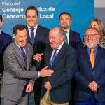 El presidente de la Junta, Juanma Moreno (c), bromea con el presidente de la FAMP, Fernando Rodríguez Villalobos (2d), junto al consejero de Justicia, Administración Local y Función Pública, José Antonio Nieto (i), durante la pose para la foto de familia al comienzo de la reunión del pleno del Consejo de Concertación Local celebrada este lunes en el Palacio de San Telmo en Sevilla. EFE/ Julio Muñoz