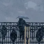 Un hombre se protege de la nieve durante una jornada de nevada en la ciudad de Teruel, en las que a primera hora de la tarde se han registrado temperaturas de -1º.