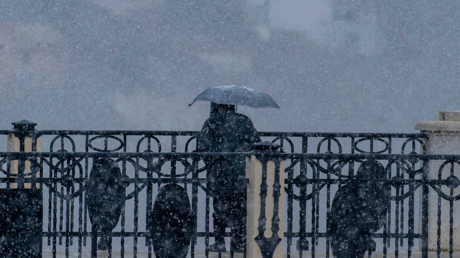 Un hombre se protege de la nieve durante una jornada de nevada en la ciudad de Teruel, en las que a primera hora de la tarde se han registrado temperaturas de -1º.