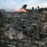 Un grupo de personas camina entre los escombros en el lugar del accidente de un avión de pasajeros cerca del pueblo de Grabovo, Ucrania.