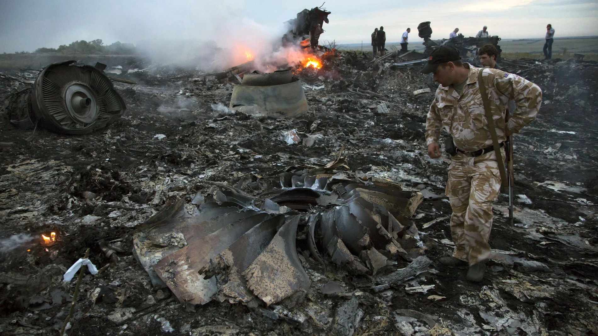Un grupo de personas camina entre los escombros en el lugar del accidente de un avión de pasajeros cerca del pueblo de Grabovo, Ucrania.