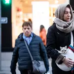Imagen de una chica que porta un gato, arropados con una bufanda por las bajas temperaturas en la capital