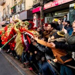 Varias personas acercan un dragón a la gente durante la celebración del pasacalles del Año Nuevo Chino 2023, en el distrito de Usera