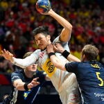 Jonathan Carlsbogard y Max Darj tratan de frenar a Álex Dujshebaev, que firmó una segunda parte fantástica para que España ganara el bronce