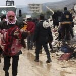 Un hombre lleva el cuerpo de una víctima del terremoto en el pueblo de Besnia, cerca de la frontera turca, provincia de Idlib, Siria