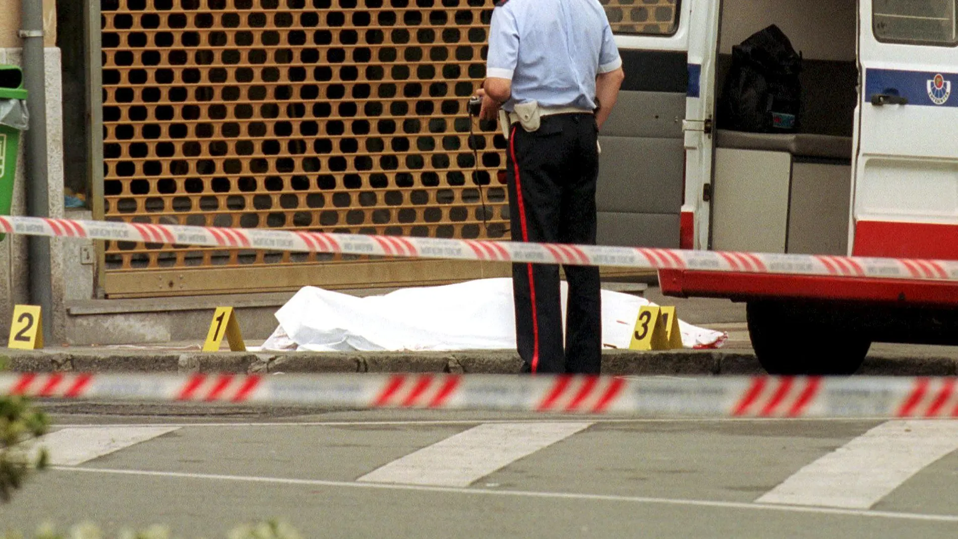 .Durango(Vizcaya). 4 jun 00.- Un agente de la Ertzaintza junto al cuerpo del concejal del PP, Jesus Maria Pedrosa, de 57 años, tras ser asesinado hoy en la localidad vízcaina de Durango