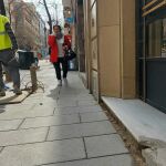 Una mujer camina junto a un hoyo lleno de cables no señalizado en el portal de la calle Ponzano número 59, dañado por las obras de ampliación de las aceras