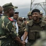 Willy Ngoma, portavoz del M23, estrecha la mano del comandante de la Fuerza Regional de la CAO tras la retirada de la guerrilla de Kibumba, este 23 de diciembre.