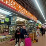 Una pareja de ancianos sale de un pequeño comercio en el Mercado Santa María de la Cabeza en Arganzuela.