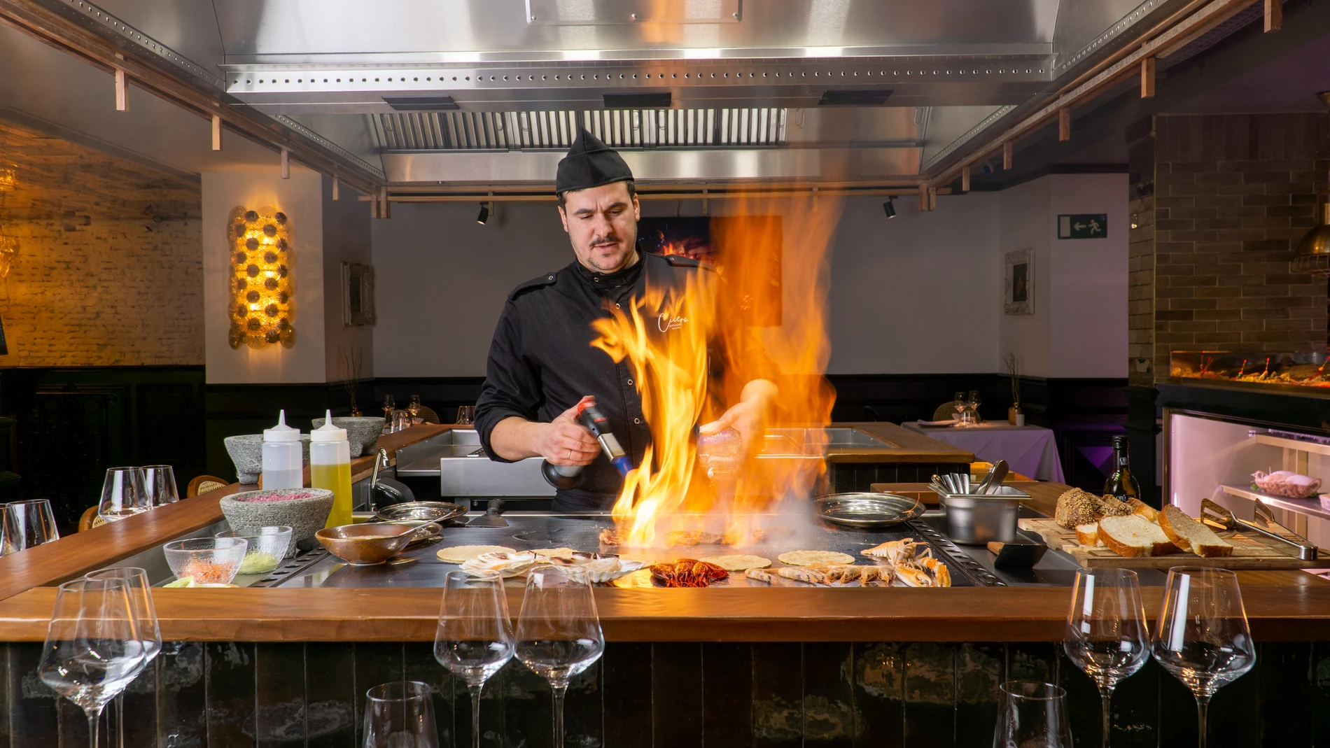 Chef cocinando en directo para los 18 comensales de "la gran mesa cuadrada"