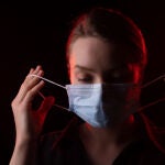 Mujer con mascarilla y covid persistente
