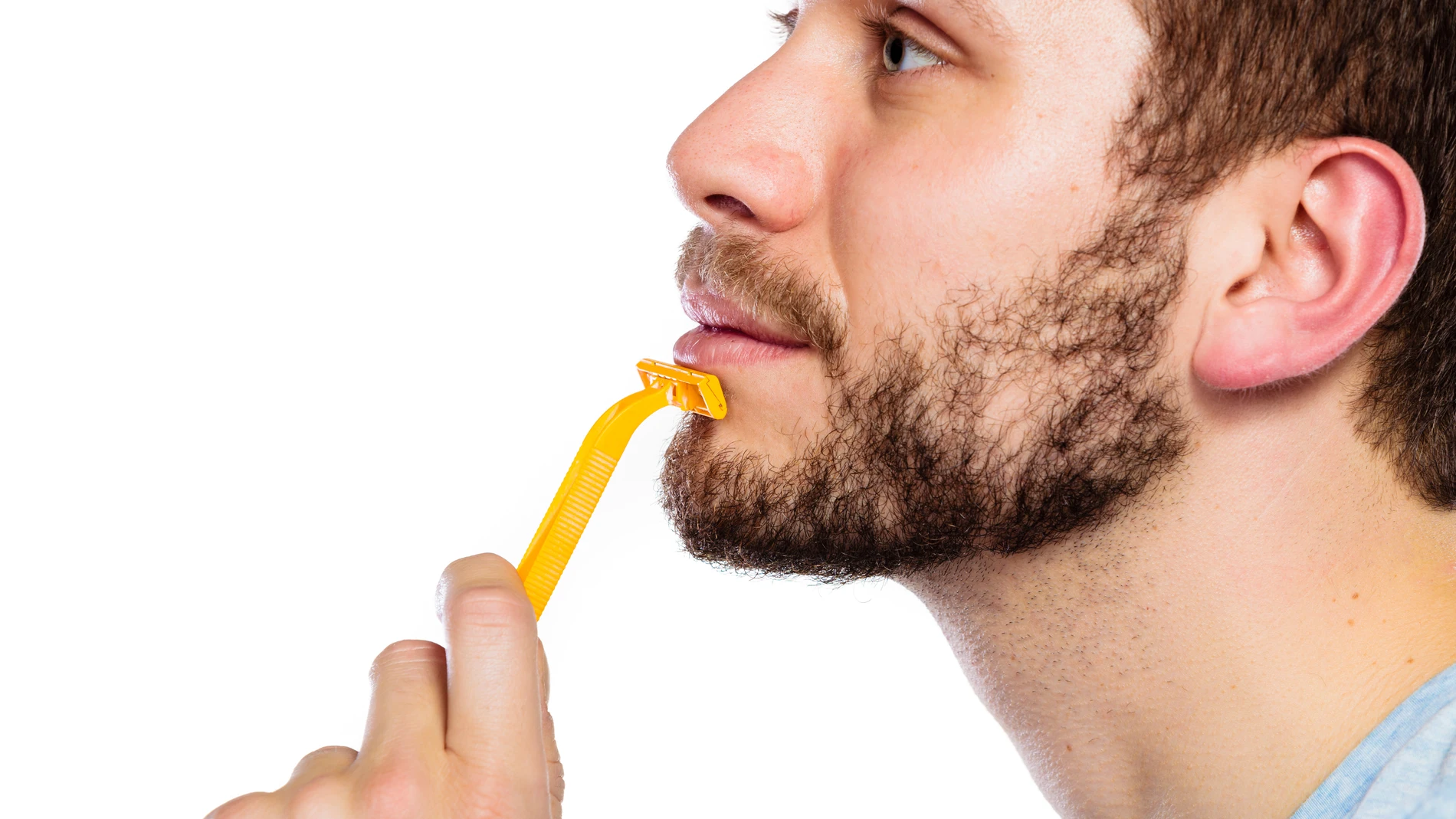 Hombre joven con barba que sostiene una cuchilla de afeitar