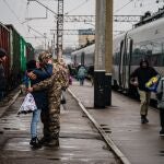 A Ukrainian serviceman embraces his wife as she arrives from Kyiv at the train station in Kramatorsk on February 26, 2023, amid the Russian invasion of Ukraine.