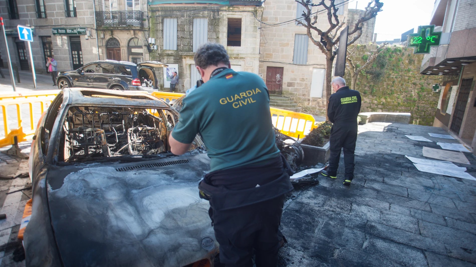 Agentes de la Guardia Civil toman muestras de los vehículos calcinados en Tuy, a 20 de marzo de 2023, en Tuy, Pontevedra, Galicia (España). Un total de 21 coches han ardido en la madrugada de hoy en la localidad pontevedresa de Tui al registrarse al menos seis puntos de fuego en diferentes zonas del casco histórico de la ciudad. Tal como han informado fuentes del Ayuntamiento y del 112 Galicia, fue minutos antes de las cuatro de la mañana cuando se tuvo constancia del primer fuego. A partir de ahí, el Centro Integrado de Atención ás Emerxencias 112 Galicia comenzó a recibir un "goteo constante" de llamadas desde diferentes calles del casco viejo describiendo un escenario similar.20 MARZO 2023;COCHES CALCINADOS;PONTEVEDRA;TUYGustavo de la Paz / Europa Press20/03/2023