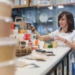 Eva, comercial de Envapro, coloca los envases de cartón, maíz y caña de azúcar de distintas marcas y genéricas en su almacén en Getafe.