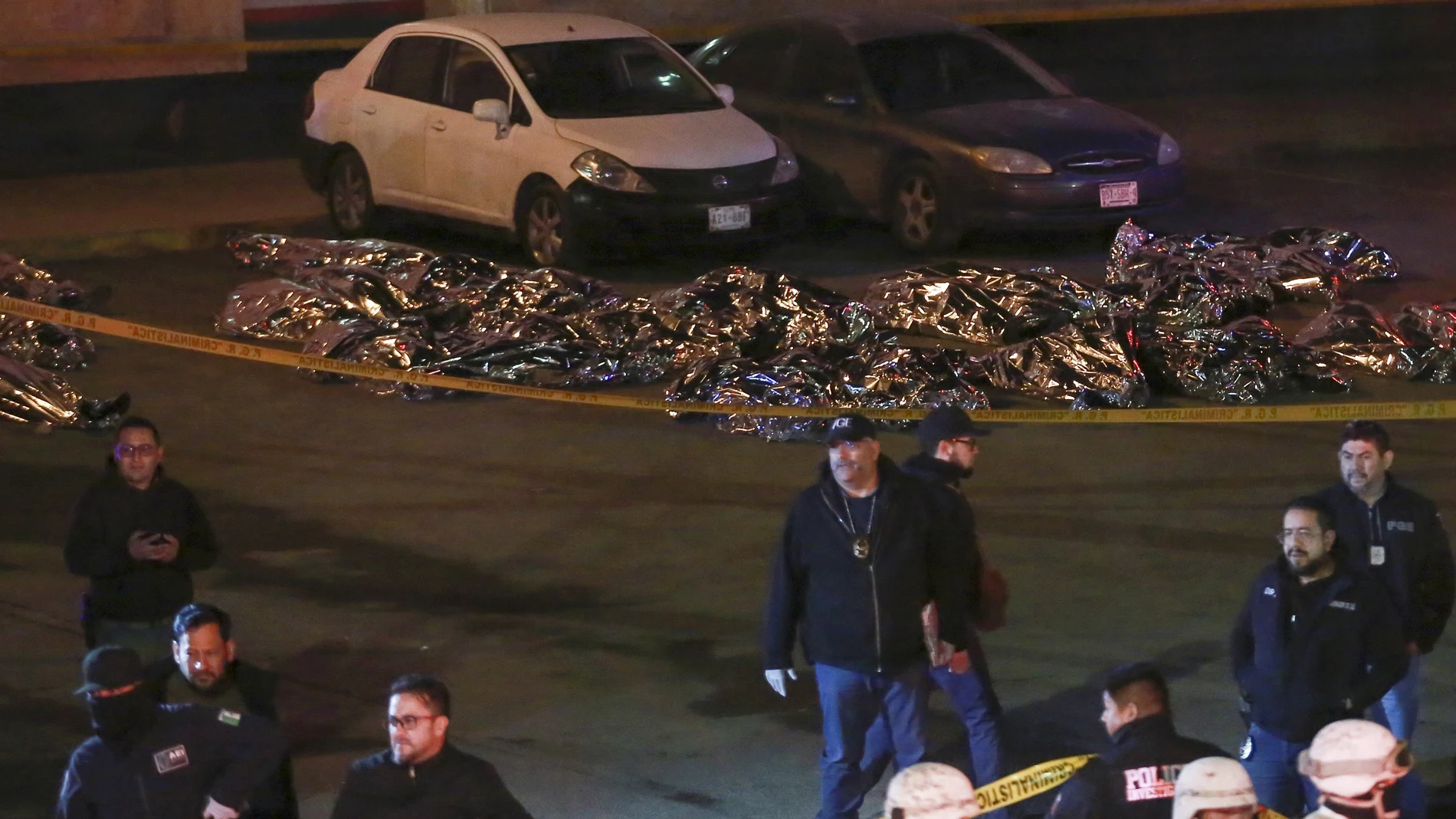 The bodies of migrants lay covered after a deadly fire broke out at an immigration detention center in Ciudad Juarez, Mexico, Tuesday, March 28, 2023.