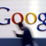 A man passes by a Google logo in Frankfurt, Germany,