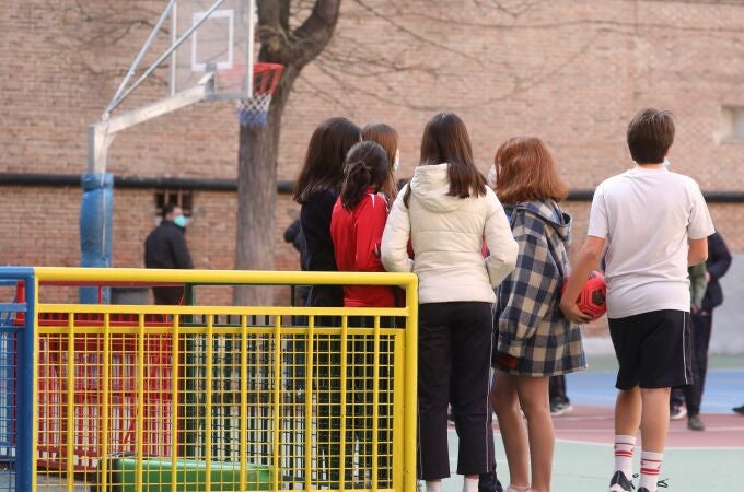 Un grupo de niños en el patio de un colegio.