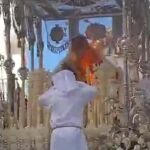 Un integrante de la comitiva procesional intenta apagar las llamas 
