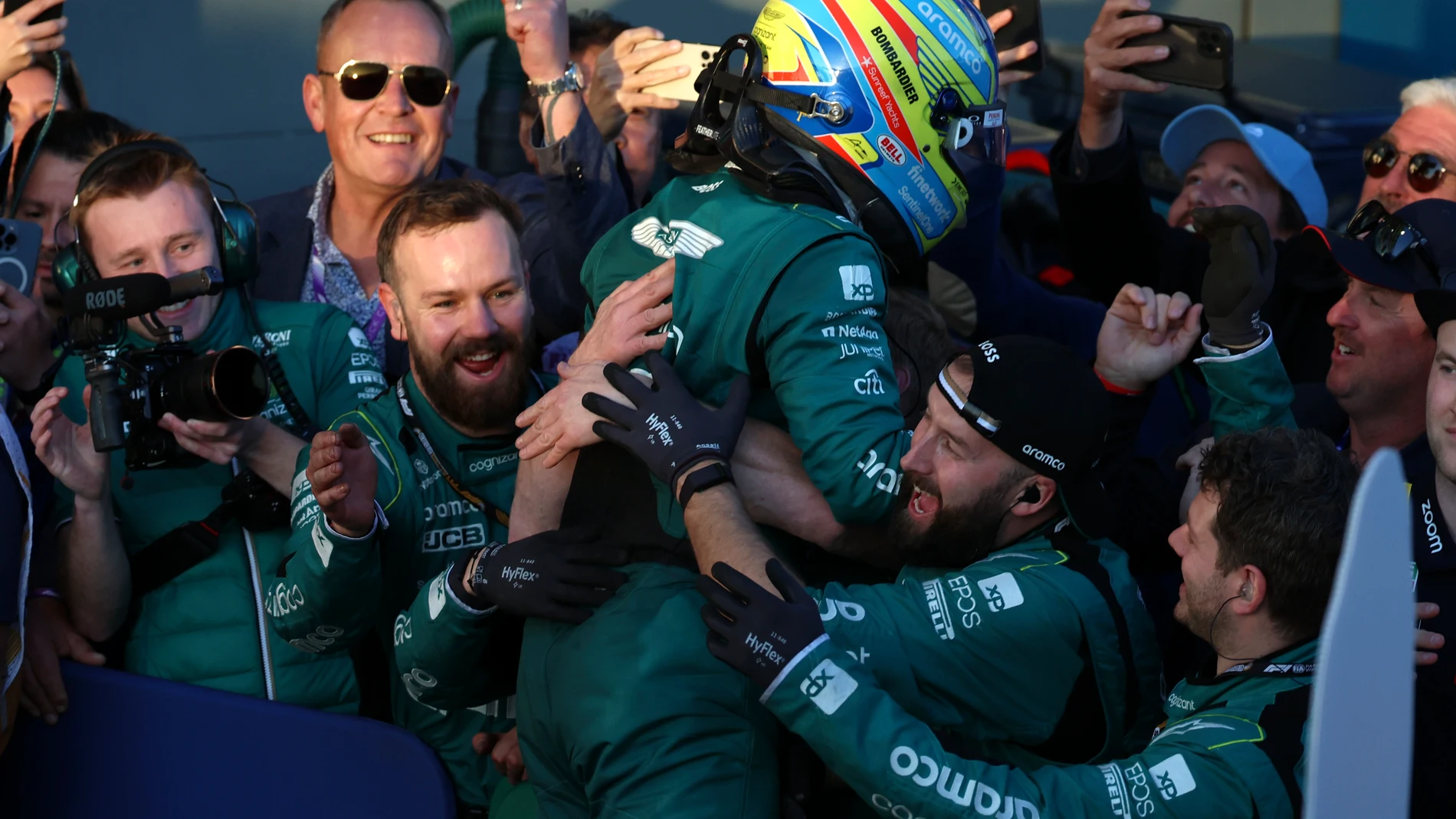 Third place getter Aston Martin driver Fernando Alonso of Spain jumps int the terms of team members after the Australian Formula One Grand Prix at Albert Park in Melbourne, Sunday, April 2, 2023. (AP Photo/Asanka Brendon Ratnayake)