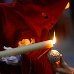 Un nazareno echa cera de su vela a una bola