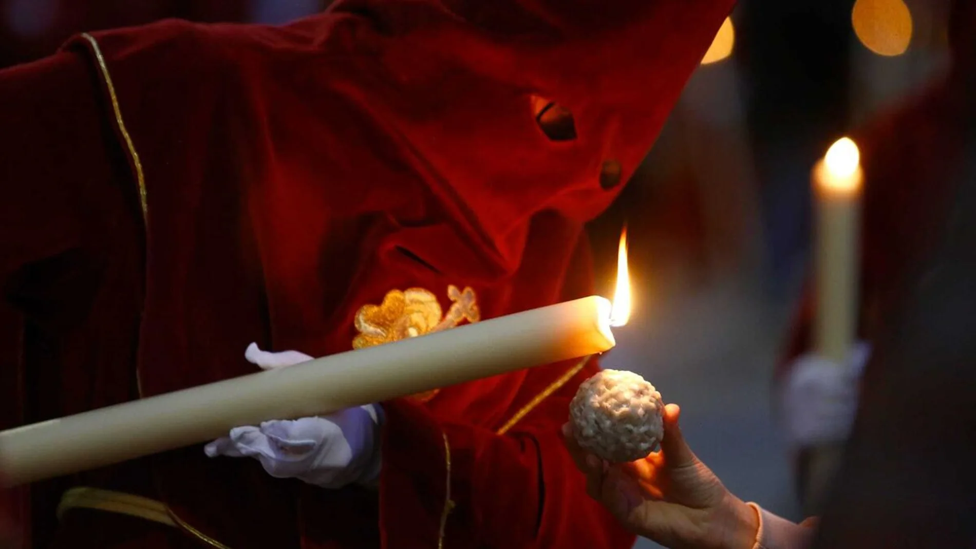 Un nazareno echa cera de su vela a una bola