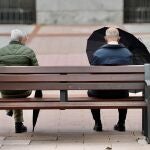 Dos pensionistas jubilados sentados en un banco