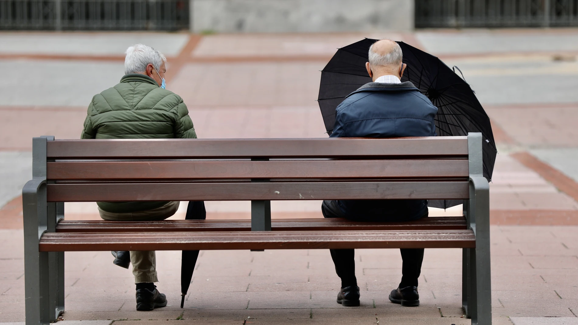 Dos pensionistas jubilados sentados en un banco