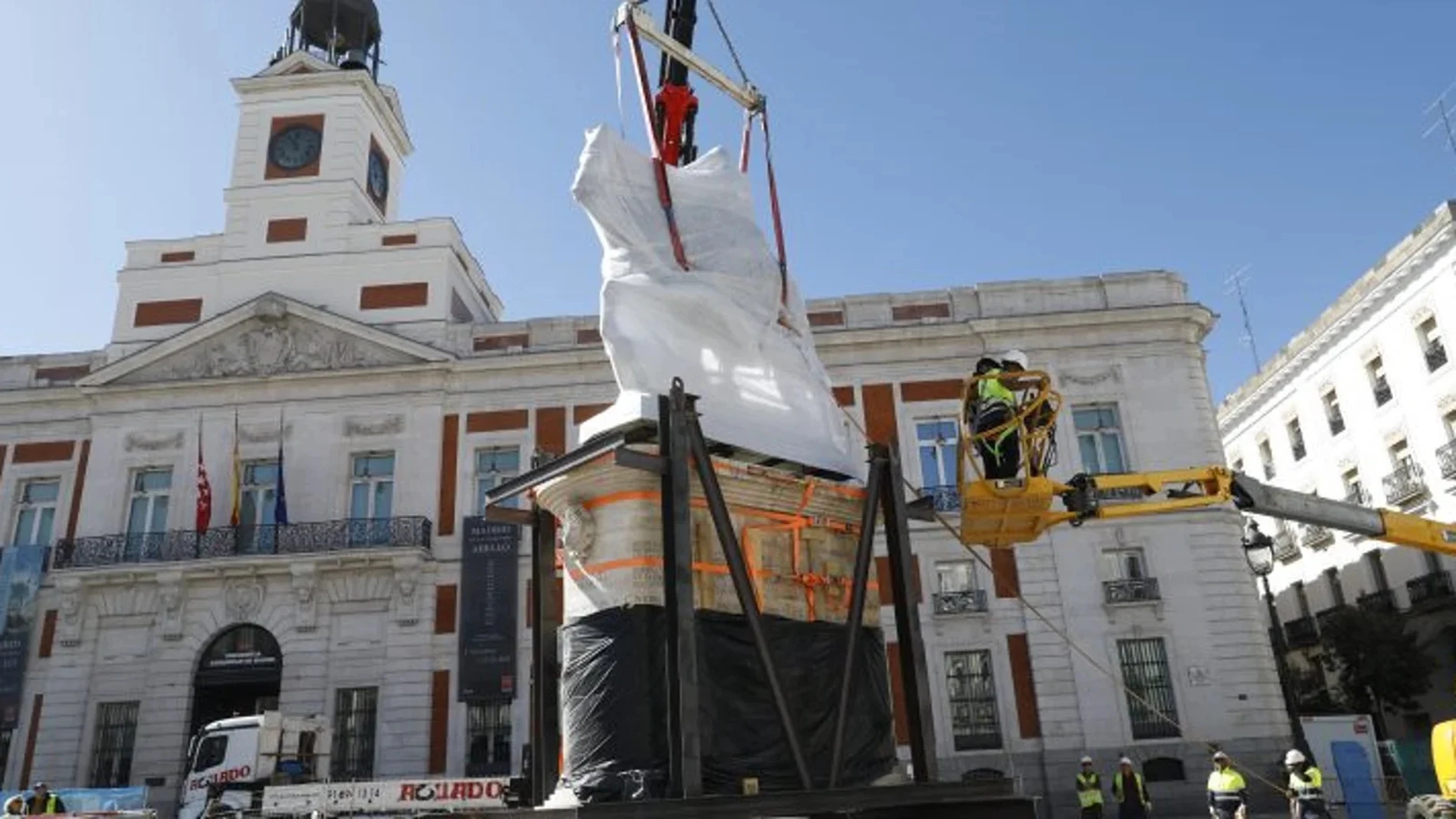 Varios obreros suben de nuevo la estatua de Carlos III a su pedestal este lunes en su nueva ubicación en la Puerta del Sol de Madrid.