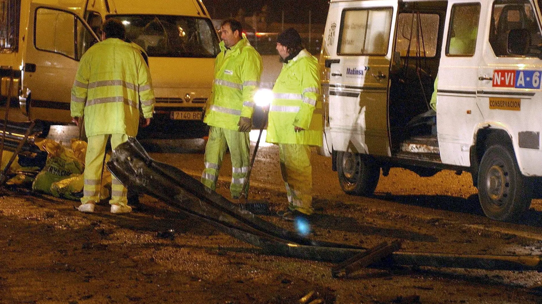 MD115 - COLLADO VILLALBA (MADRID), 17-12-02.- Los empleados del Ayuntamiento limpian los restos del coche que expertos en desactivación de explosivos de la Guardia Civil (TEDAX) explosionaron esta tarde, a la altura del kilómetro 38 de la A-6 en sentido Madrid, en el que viajaban los autores del tiroteo en el que esta tarde resultó muerto un guardia civil.