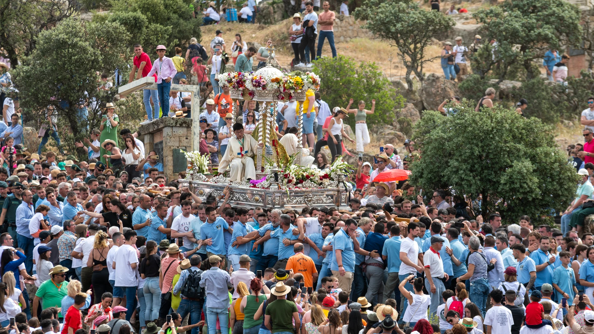 La Virgen de la Cabeza acompañada de dos trinitarios y portada por los anderos baja la calzada en procesión