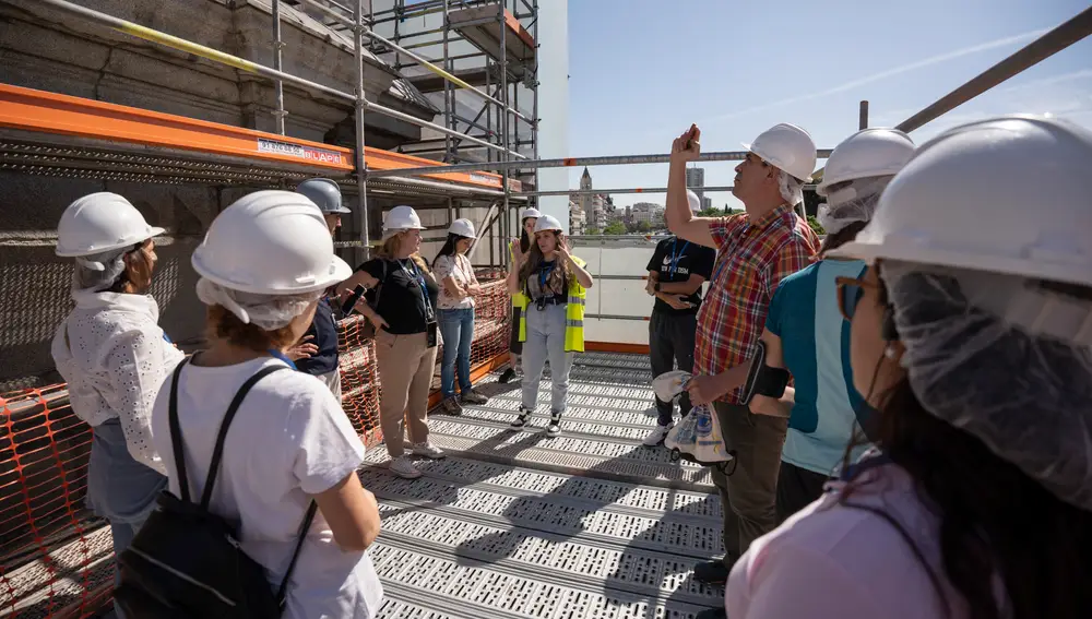 Nuria Álvarez, historiadora de arte, contaba este sábado los trabajos de restauración de la Puerta de Alcalá a los 25 visitantes mientras uno Raúl Oter hace una foto al emblemático monumento.