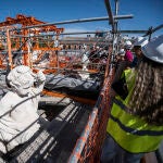 Nuria Álvarez explica los trabajos de restauración y la historia de la Puerta de Alcalá a los 25 visitantes de la primera visita a las obras de conservación de este emblemático monumento.