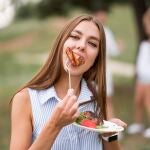 Mujer comiendo un filete de carne