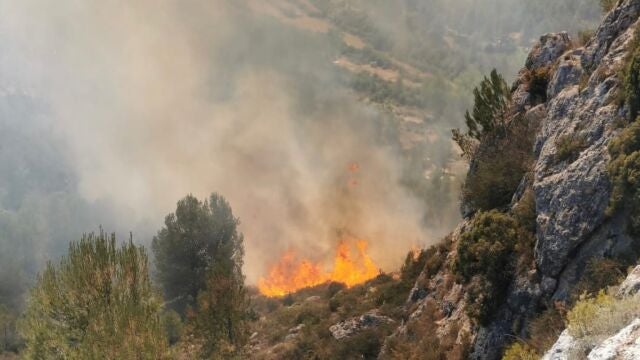 Castellón.- Medios terrestres y aéreos trabajan en la extinción de un incendio forestal en Viver