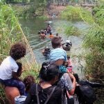 Migrantes cruzan el río Bravo para intentar ingresar a Estados Unidos hoy, en Matamoros (México). En la agonía del Título 42, los migrantes que se encuentran varados en la frontera de Matamoros, Tamaulipas, en el norte de México, han padecido crisis nerviosas y no han dejado de lanzarse al río Bravo durante este jueves, mientras los militares estadounidenses refuerzan la malla con púas y más agentes se suman a su tarea en la zona que las familias emplean para cruzar.