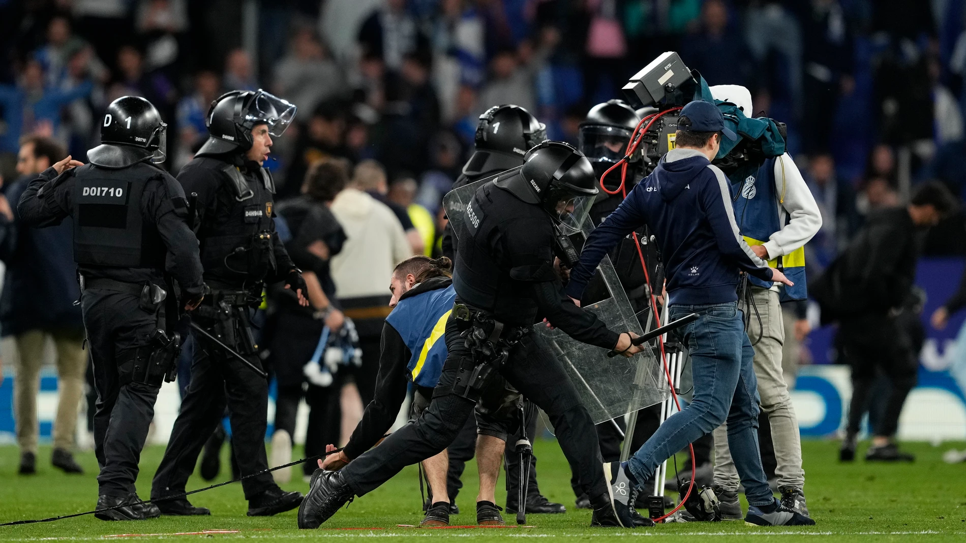 CORNELLÁ DE LLOBREGAT (BARCELONA), 14/05/2023.- La policía carga contra los aficionados que han invadido el campo al término del partido que el RCD Espanyol y el FC Barcelona han disputado este domingo en el RCDE Stadium de Cornellá de Llobregat (Barcelona). EFE/ Alejandro Garcia
