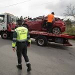 Un Guardia Civil vigila la retirada de un coche siniestrado en Xove, Lugo.