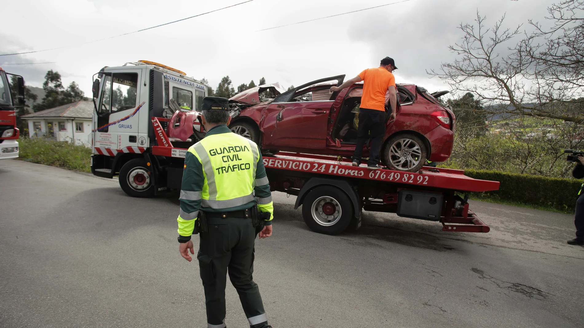 Un Guardia Civil vigila la retirada de un coche siniestrado en Xove, Lugo.