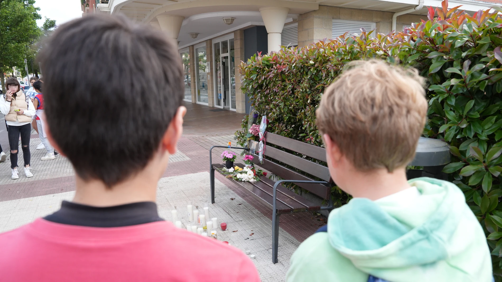 Dos niños observan las flores y velas depositadas en el lugar en el que se produjo el asesinato machista en Orio, a 17 de mayo de 2023, en Orio, Guipúzcoa, País Vasco (España). Ayer ocurrió un asesinato machista en la localidad. El asesino disparó a su expareja a bocajarro con una escopeta manipulada y acto seguido se suicidó. Numerosos vecinos de Orio se han acercado hasta el banco donde tuvieron lugar los hechos y allí han depositado flores y velas en memoria de la víctima. Esta es desde ayer la primera víctima mortal de violencia de género en el País Vasco este 2023.17 MAYO 2023;ASESINATO;VÍCTIMA;MACHISTA;VIOLENCIA;CRIMEN;ESCOPETA;FLORES;VELAS;MEMORIA;PRIMERAUnanue / Europa Press17/05/2023